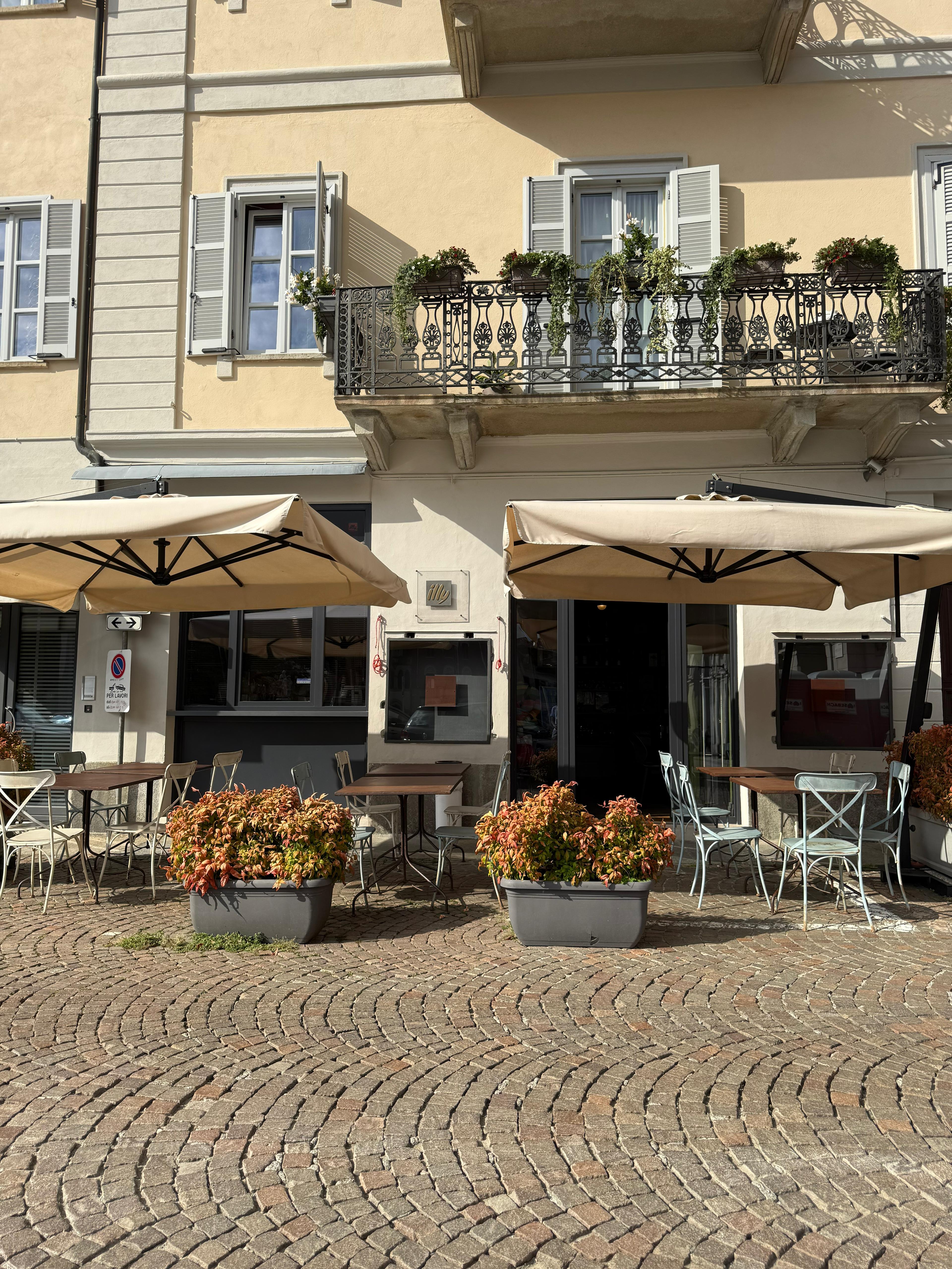Facciata del bar in Piazza Duomo, Biella, con dehors esterno e insegna visibile.